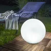 A glowing sphere sits on a wooden deck next to a lounge chair at night. Produktbild-Vorschau