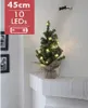 A small, decorated Christmas tree on a white mantelpiece. Produktbild-Vorschau