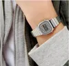 A close-up shot of a person's wrist wearing a silver digital watch. Podgląd zdjęcia produktu