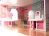 Interior of a dollhouse kitchen with pink and teal accents. Voir les images du produit