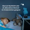 A child is sleeping in bed next to a teddy bear, with a 3D LED teddy bear lamp on a nightstand. Produktbild-Vorschau