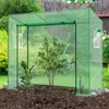A green greenhouse with plants inside, set in a garden. Produktbild-Vorschau