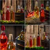 A collage of four images showing glass bottles filled with colored liquids, arranged in rustic settings with wooden backgrounds and straw. Produktbild-Vorschau