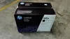 A black HP LaserJet toner cartridge box sits on a concrete floor with a yellow line in the background. Náhľad obrázku produktu