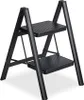 A black two-step folding ladder is shown against a white background. Voir les images du produit