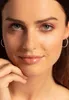 Close-up of a woman's face wearing earrings. Produktbild-Vorschau