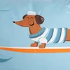 A cartoon dachshund wearing a sailor outfit and a striped shirt is surfing on an orange surfboard against a light blue background. Podgląd zdjęcia produktu