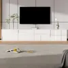 A modern white TV stand with a large black TV mounted above it, set in a clean, minimalist room. Anteprima dell’immagine prodotto