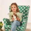 A young girl sits in a polka-dot armchair holding a stuffed bunny. Anteprima dell’immagine prodotto