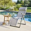 A lounge chair and side table are set up next to a swimming pool on a sunny day. Produktbild-Vorschau