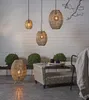 An outdoor patio setting with rattan-style lighting fixtures and furniture. Produktbild-Vorschau