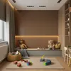 A child's playroom with wooden slat wall panels, a built-in bench, and toys scattered on the floor. Náhled obrázku produktu