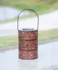 A decorative solar lantern with a handle, sitting on a ledge outdoors. Produktbild-Vorschau