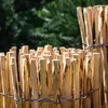 A close-up view of a wooden fence made of pointed stakes bound together with wire. Produktbild-Vorschau