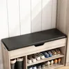 A shoe bench with storage compartments filled with shoes, positioned against a paneled wall. Podgląd zdjęcia produktu