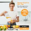 A woman is pouring freshly squeezed orange juice into a glass, with a collection of citrus fruits and a juicer base visible on the counter. Produktbild-Vorschau