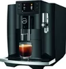 A black Jura E8 coffee machine with a glass of espresso in front of it. Podgląd zdjęcia produktu