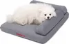 A small white dog is lying on a gray dog bed with bolsters. Náhled obrázku produktu