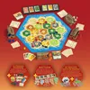 A flat lay of the Catan board game and its expansions, presented on a red background. Voir les images du produit