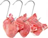 Four raw pork chops are hanging from metal hooks against a white background. Produktbild-Vorschau