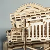 A close-up view of a wooden mechanical model kit, likely a marble run or robot. Podgląd zdjęcia produktu