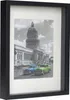 A framed picture of a building with two vintage cars in front. Produktbild-Vorschau