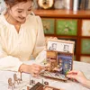 A woman is assembling a miniature wooden book nook. Podgląd zdjęcia produktu