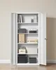 An open white metal cabinet filled with storage boxes, binders, and books on shelves. Náhled obrázku produktu