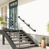 A black metal handrail is installed on a white exterior wall next to a set of outdoor stairs. Produktbild-Vorschau