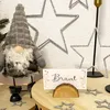 A festive table setting with a gnome decoration, stars, and a place card. Produktbild-Vorschau
