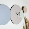 A modern wall clock with overlapping circular elements in different pastel colors. Produktbild-Vorschau