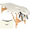 A cream-colored massage table with wooden legs and a carrying case. Voir les images du produit