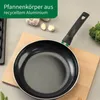A frying pan is placed on a wooden cutting board, with garlic and broccoli in the background. Produktbild-Vorschau