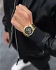 A person wearing a black jacket and a gold Maserati chronograph watch. Náhled obrázku produktu