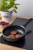 A frying pan with pancakes and berries on a wooden table. Voir les images du produit
