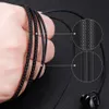 A hand holding black earphones, with close-up insets showing the cable texture. Podgląd zdjęcia produktu