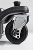 A close-up view of a wheel and part of the frame of a lawnmower. Produktbild-Vorschau