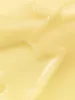 A close-up abstract texture of a creamy, pale yellow substance, possibly a cosmetic product. Voir les images du produit