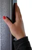 A hand is shown touching the side of a dark textured object, possibly a part of the pergola frame. Náhled obrázku produktu