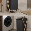 A laundry basket and a washing machine in a bathroom setting. Podgląd zdjęcia produktu