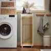 A laundry room scene with a washing machine, a tall cabinet with slatted doors, and towels hanging on a rack. Anteprima dell’immagine prodotto