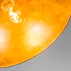 A close-up view of a golden-colored lamp shade with a lit light bulb. Anteprima dell’immagine prodotto