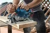 A person is using a cordless circular saw to cut a wooden plank on a construction site. Anteprima dell’immagine prodotto