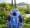 A Stitch figurine sits in a garden with flowers. Produktbild-Vorschau