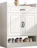 A white shoe cabinet with two doors and a drawer, displaying shoes on the bottom shelf. Produktbild-Vorschau