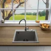 A kitchen sink and faucet are shown on a wooden countertop, with a window view of a scenic landscape in the background. Produktbild-Vorschau