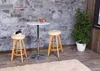 A bar table with two bar stools in a room with a stone wall and wooden paneling. Podgląd zdjęcia produktu