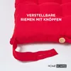A close-up of a red seat cushion with adjustable straps and buttons. Anteprima dell’immagine prodotto