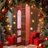 A literary advent calendar with 25 mini-books is displayed in a festive Christmas setting, surrounded by decorated trees and gift boxes. Náhled obrázku produktu