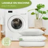 A washing machine and a stack of white pillows are shown, with text indicating washability. Voir les images du produit